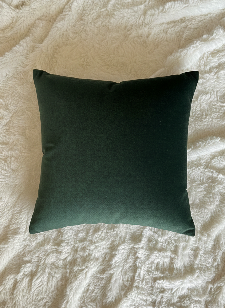 Dark green pillow on a textured beige surface
